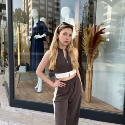 Kahverengi Çizgili Crop Eşofman Takımı giyen sarı saçlı kadın.