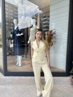 Yelekli Sarı Alt takım giyen sarı saçlı kadın.