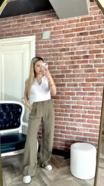 Haki Yüksel Bel Pantolon ve Düğme Yakalı Crop giyen sarı saçlı kadın.